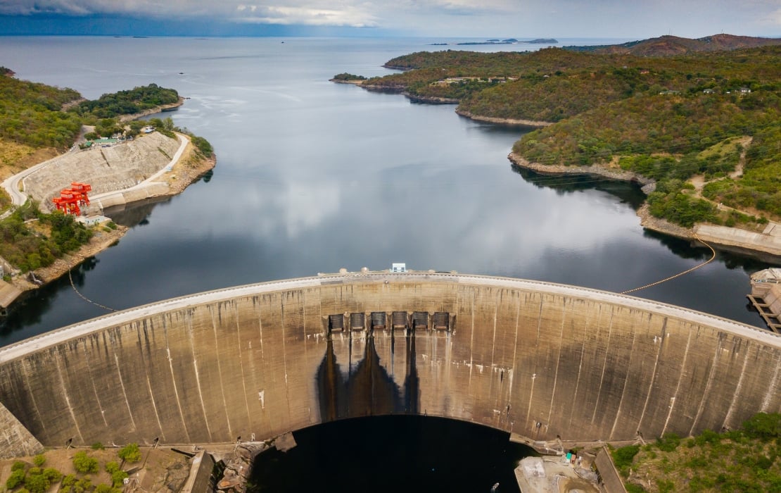 An aerial view photograph of the Kariba dam, with Lake Kariba fading into the background.