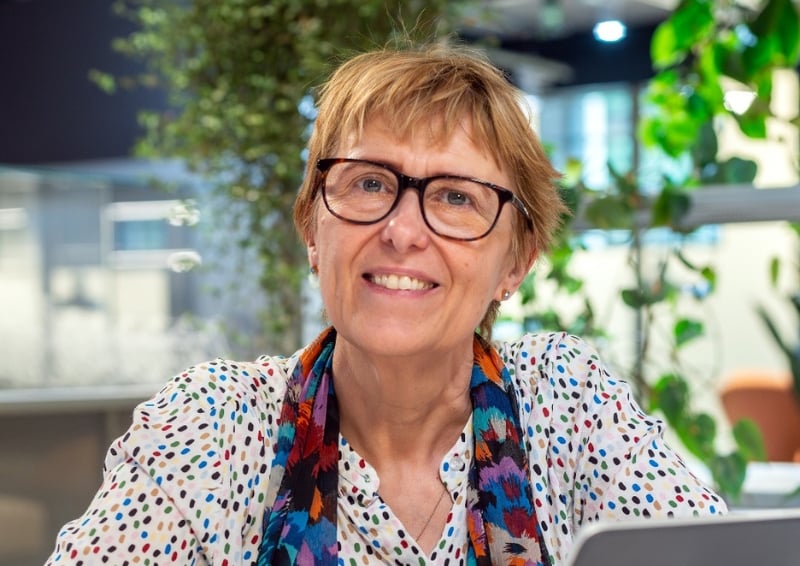 A portrait photo of Julie Wood wearing black glasses and a white blouse.