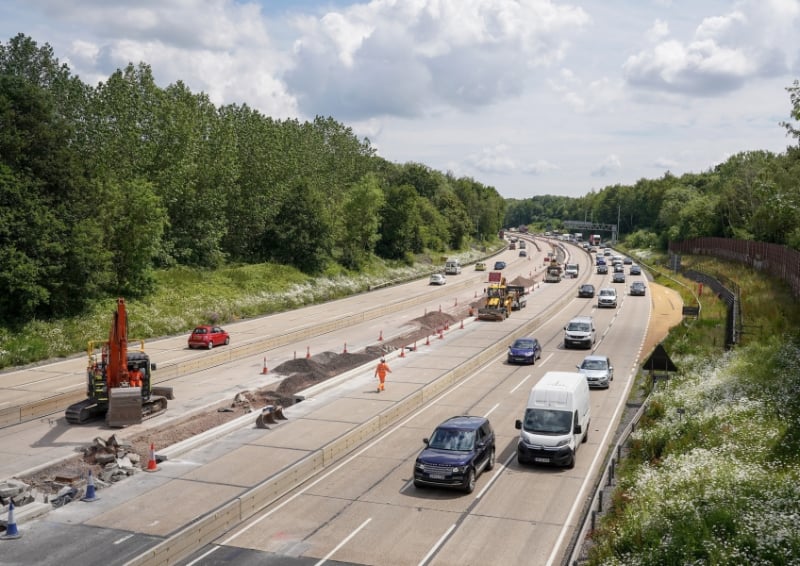 Roadworks on the M27 motorway with traffic passing through a coned-off construction area.